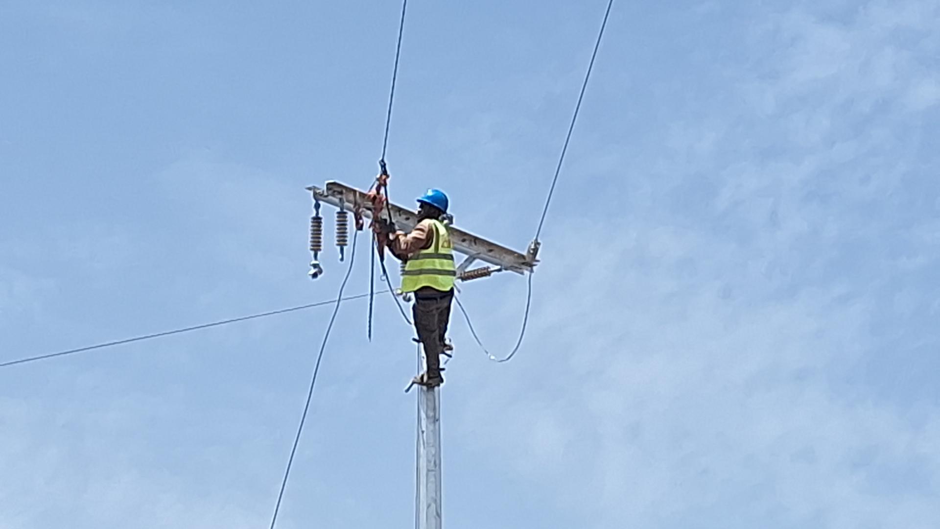 Technician connecting cables on a pole