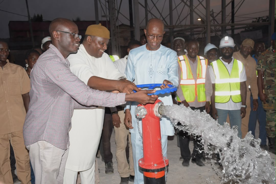 President Adama Barrow, Managing Director Gallo Saidy and Head of Water Omar Sanneh activate the water hydrant — 14 October 2026